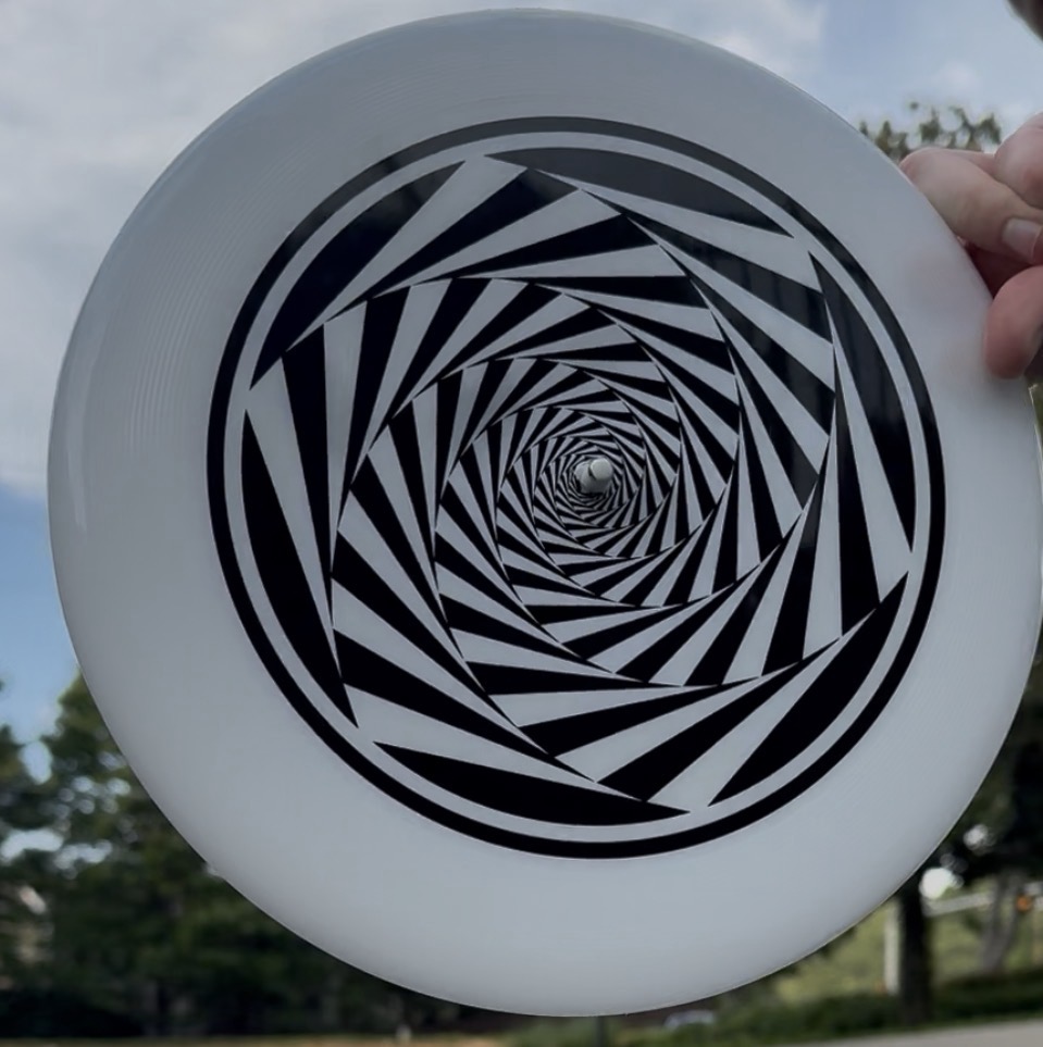 An AirPod mounted in the hole at the exact centre of a flying disc